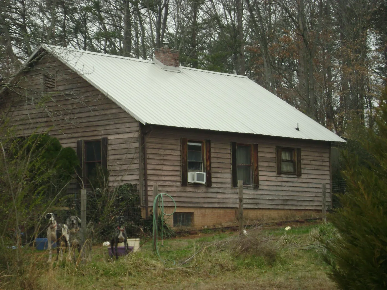 White metal roof on an old wood sided farmhouse, from a Metal Roof Installation job in Webster